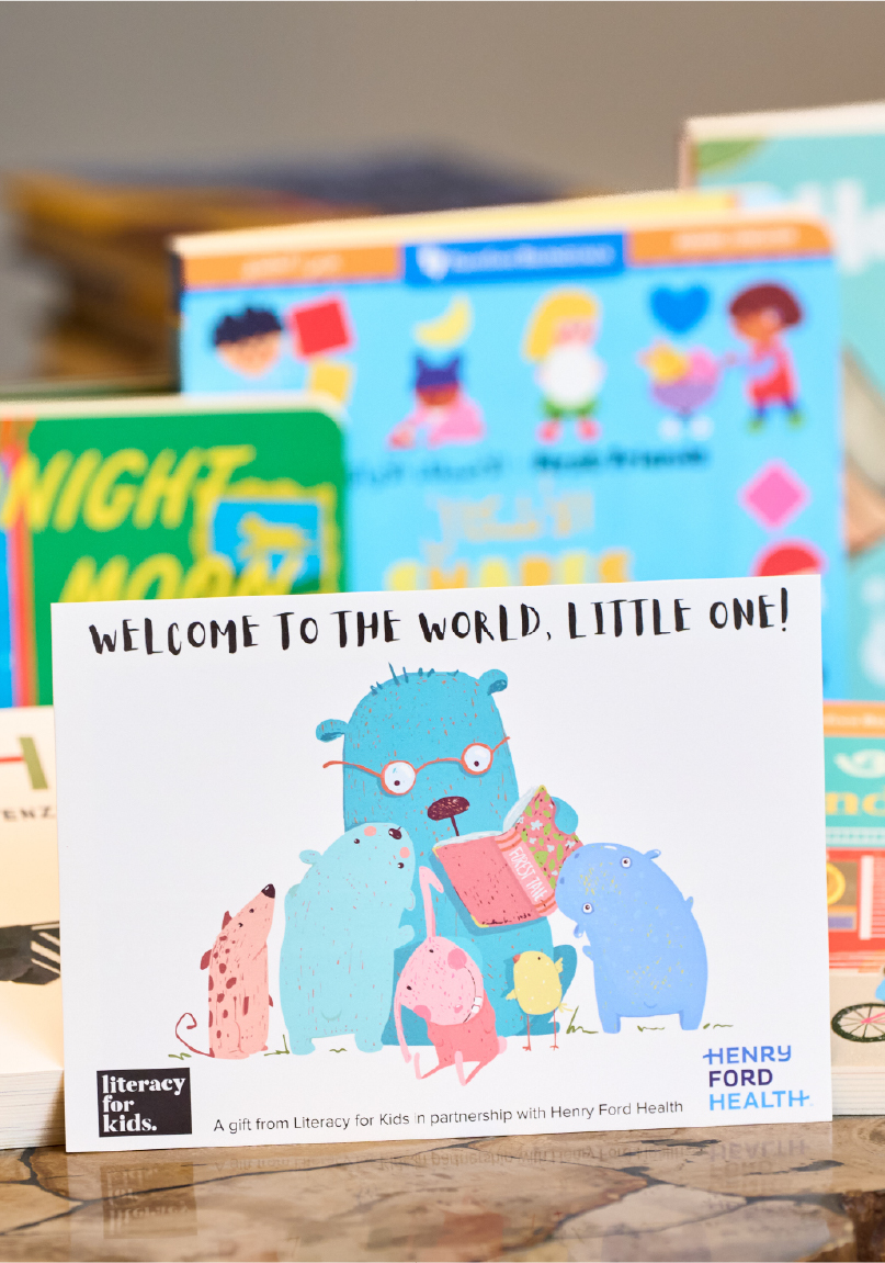 A set of books arranged on a counter with 'Welcome To The World Little One!' in focus in the foreground